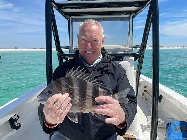 Gregg E. Lewis celebrates his victory as Florida's first Grand Slam Master Angler, holding his final catch—a stunning Sheepshead—with Captain Brandon Simon.