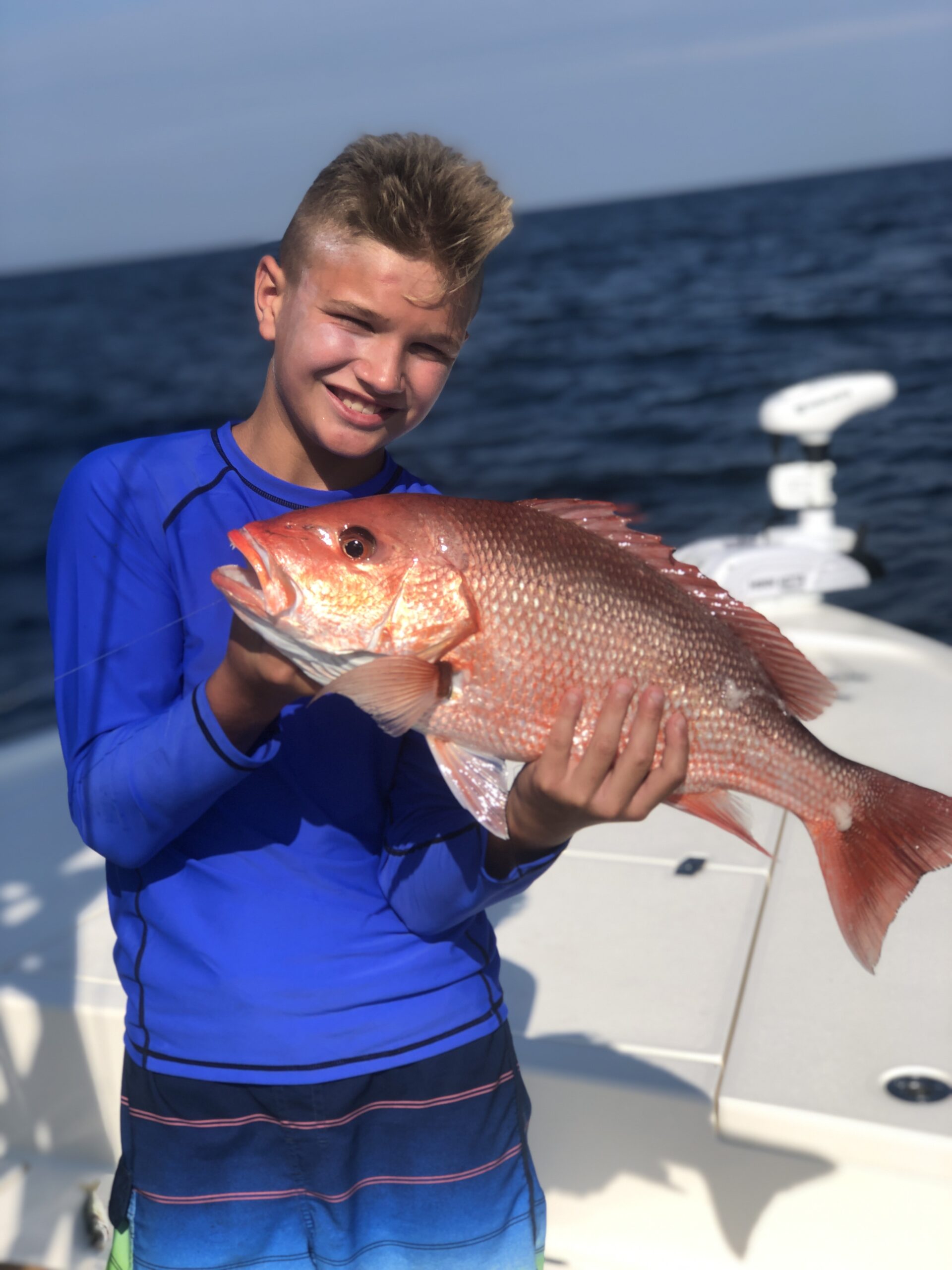 Customer holding a freshly caught red snapper on a fishing trip in the Gulf of Mexico.